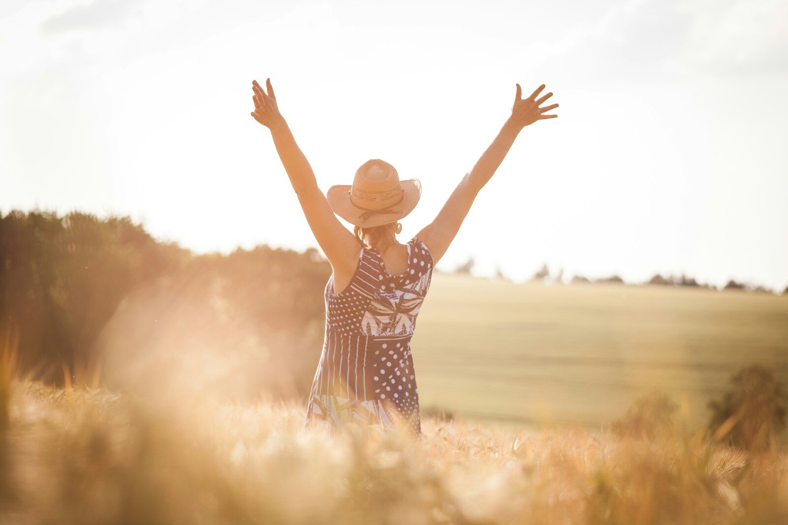 Photo by Daniel Hering woman in black and white polka dot dress raising her hands